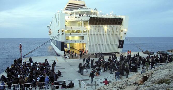 Inmigrantes procedentes del norte de África se preparan para embarcar en el ferry &#039;Excelsior&#039;, que los trasladará a otros centros de Italia, en la isla de Lampedusa