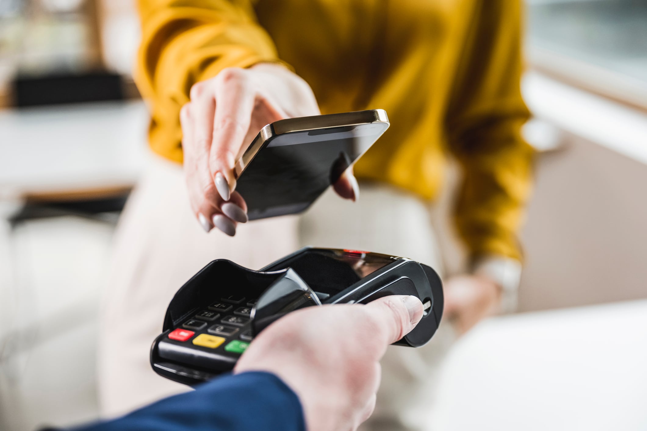 Una mujer pagando con su teléfono móvil.