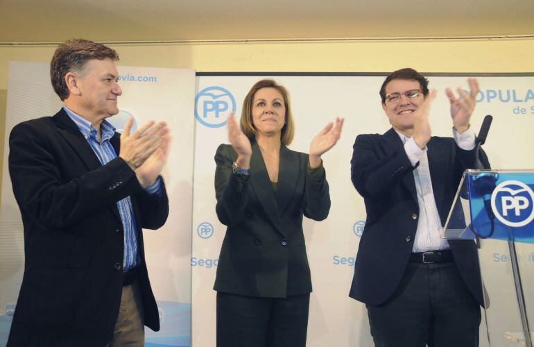 La secretaria general del PP, María Dolores de Cospedal (c), junto al secretario autonómico, Alfonso Fernández Mañueco (d), y el presidente provincial, Francisco Vázquez (i), aplaude al término del acto con alcaldes de su partido en la provincia de Segovi