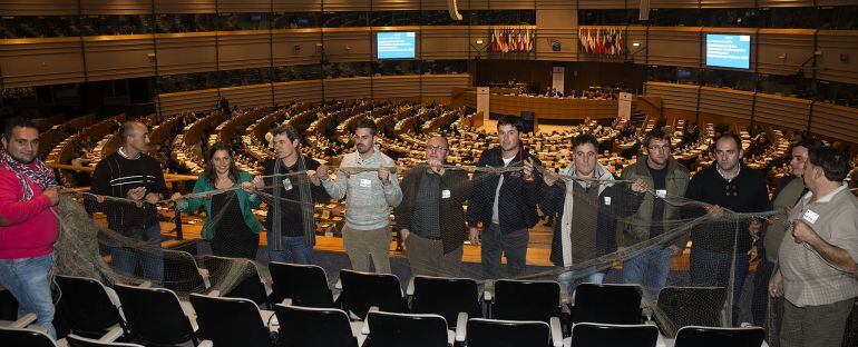 La portavoz del BNG en Bruselas, Ana Miranda, con pescadores del Xeito desplegando una red en la eurocámara en diciembre de 2014.