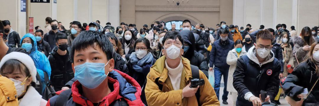 Población china con mascarillas en un lugar público