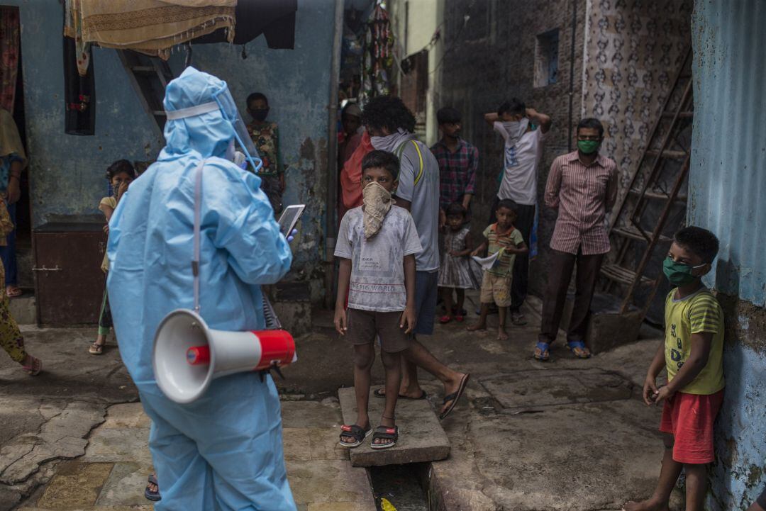 Un trabajador sanitario da pautas a la población sobre cómo protegerse del coronavirus en India.