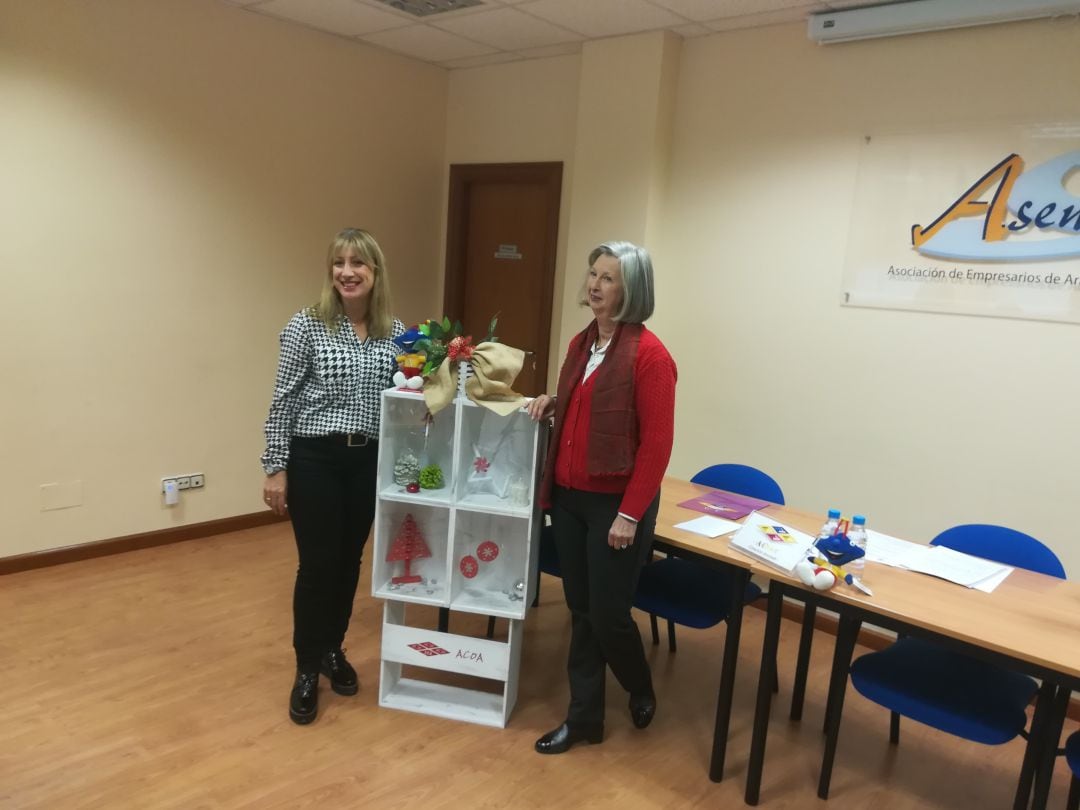 Susana de las Heras (dcha) e Isabel García Escudero posan con los adornos realizados en el taller de ASADEMA para los escaparates de ACOA