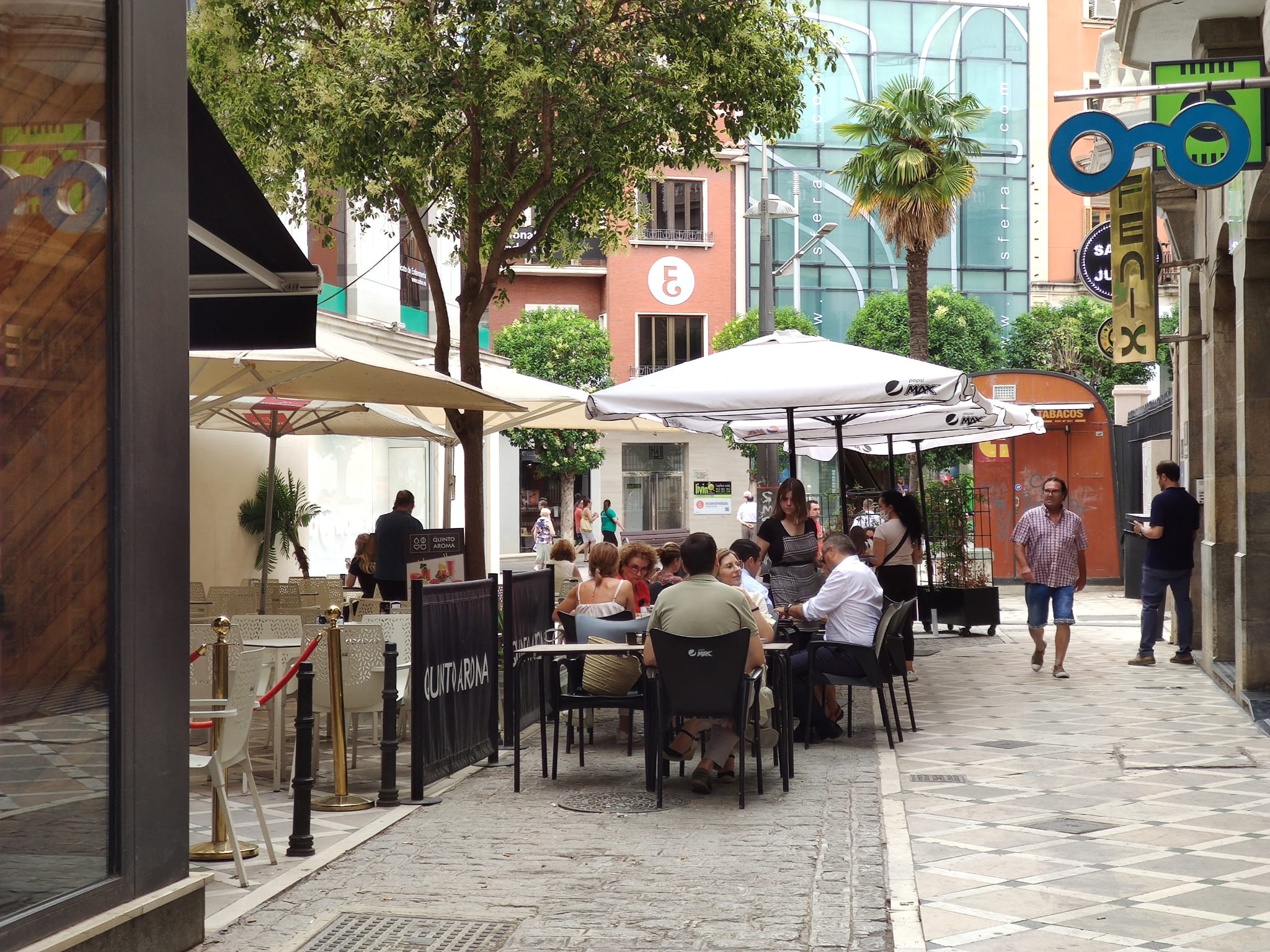 Una de las calles del centro de Jaén capital, con personas sentadas en las mesas de una terraza de restaurante