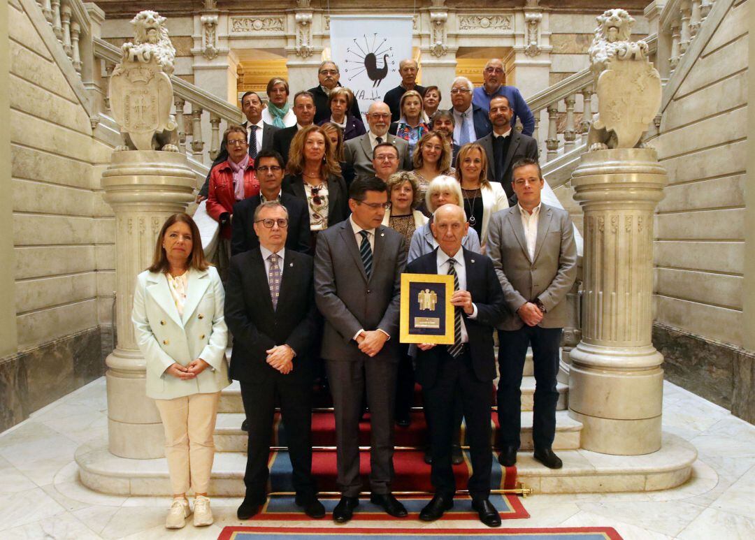 El presidente de ALCER Asturias, Rogelio García, posa sosteniendo la distinción con el presidente de la Junta General, Pedro Sanjurjo, el Consejero de Sanidad, varios diputados e invitados al acto