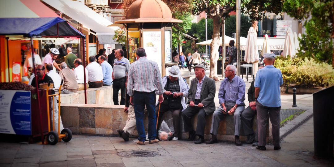 Mayores descansan en un banco en la Plaza de la Constitución.