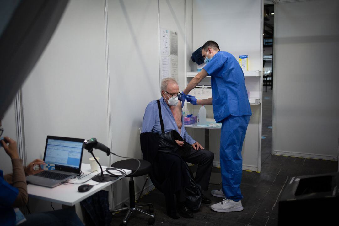 Un sanitario vacuna a un hombre en el circuito de vacunación de Fira.