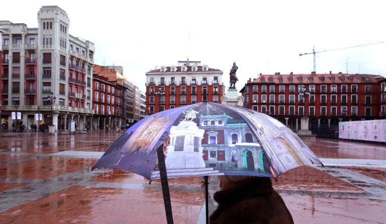 Una mujer se protege de la lluvia con un paraguas en la Plaza Mayor