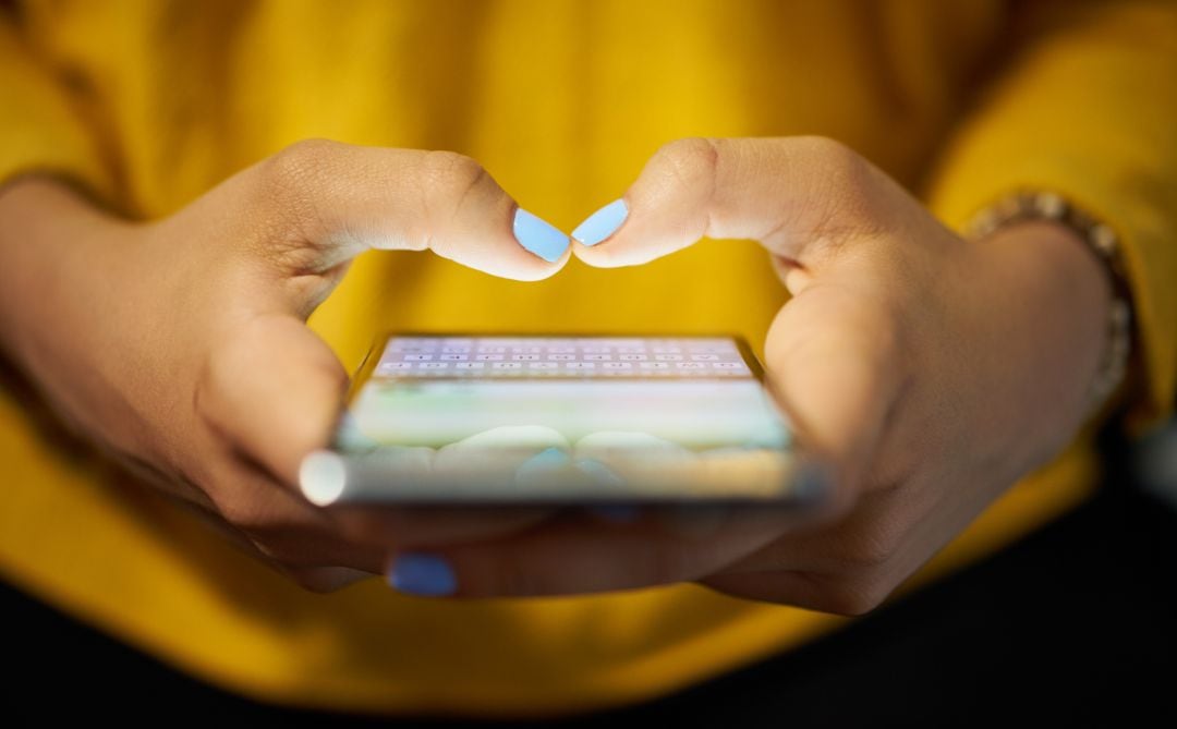 Una chica usando su teléfono móvil