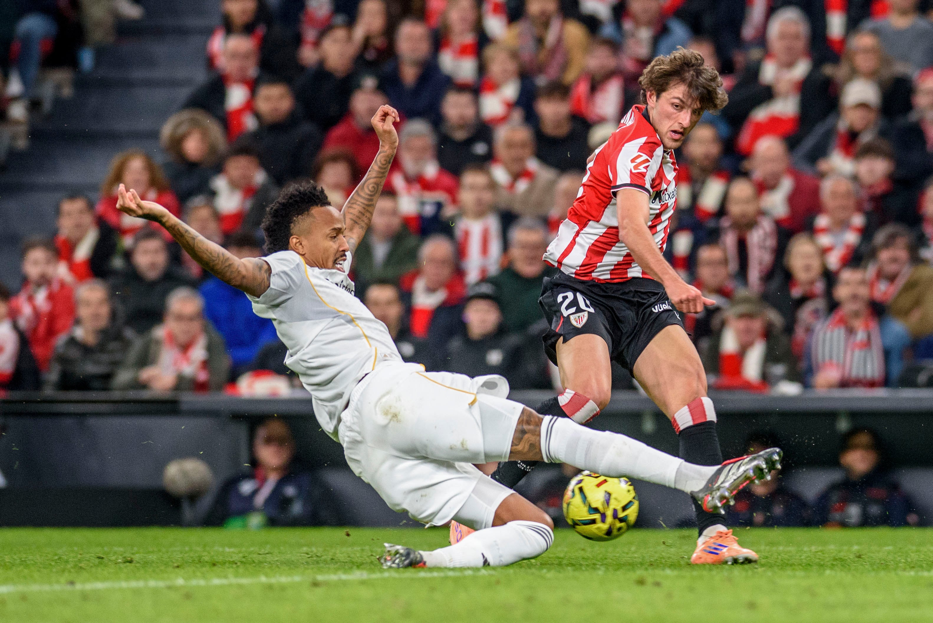 Bilbao, 03/12/2025.- El centrocampista del Athletic Club, Unai Gómez (d), golpea el balón ante el defensa brasileño del Real Madrid, Eder Gabriel Militao, durante el encuentro correspondiente a la jornada 16 de Laliga EA Sports que han disputado hoy miércoles Athletic Club y Real Madrid en el estadio de San Mamés, en Bilbao. EFE/Javier Zorrilla