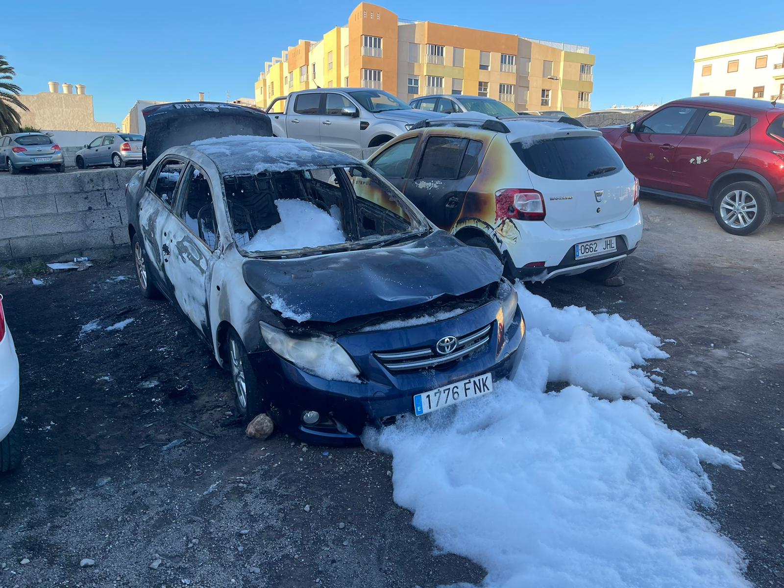 El coche calcinado junto a otro de los vehículos afectados.