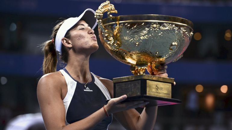 La española Garbiñe Muguruza besa su trofeo tras ganar el Abierto de Pekín, en China