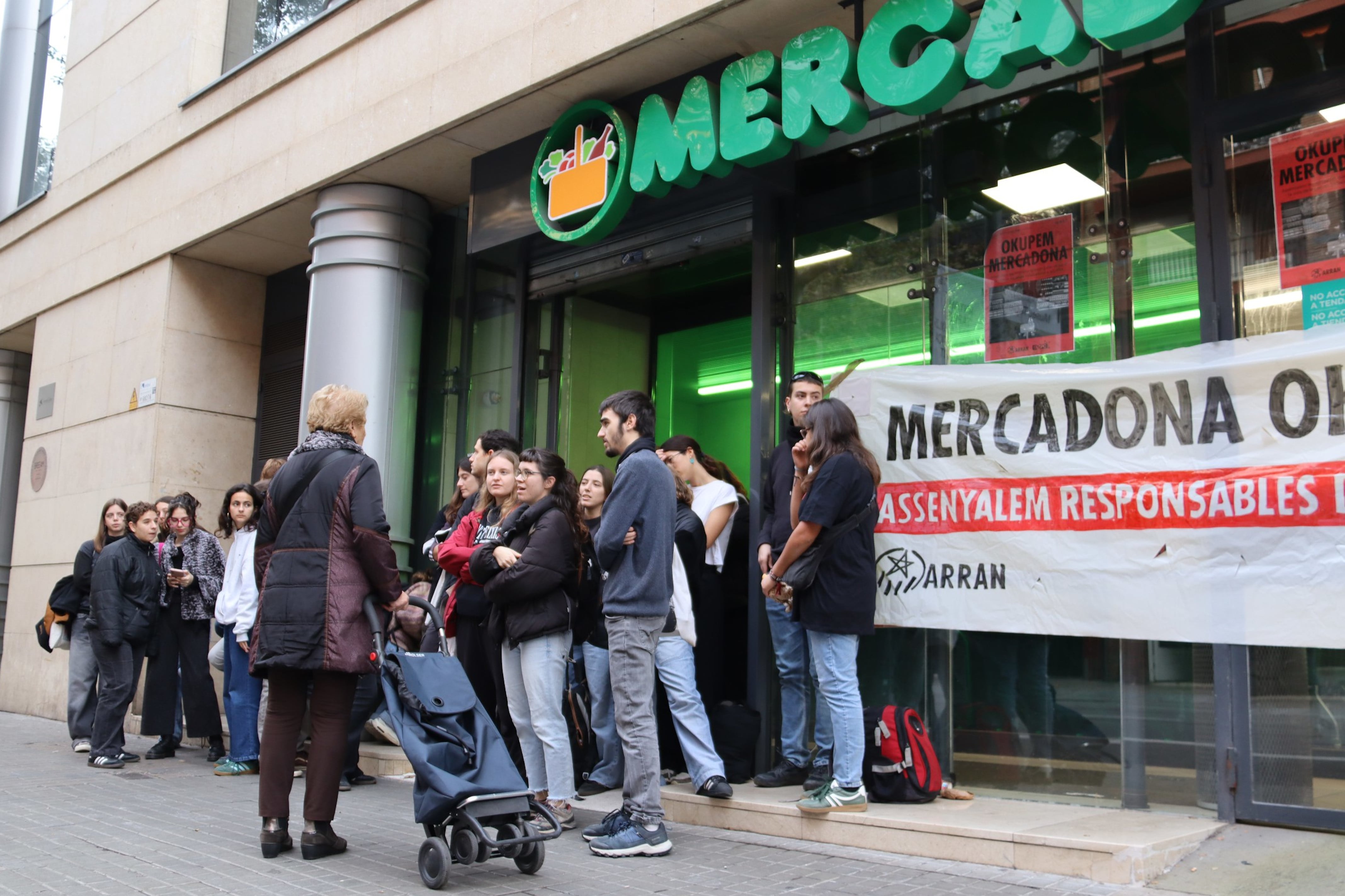 Activistes parlant amb una dona que vol accedir al supermercat