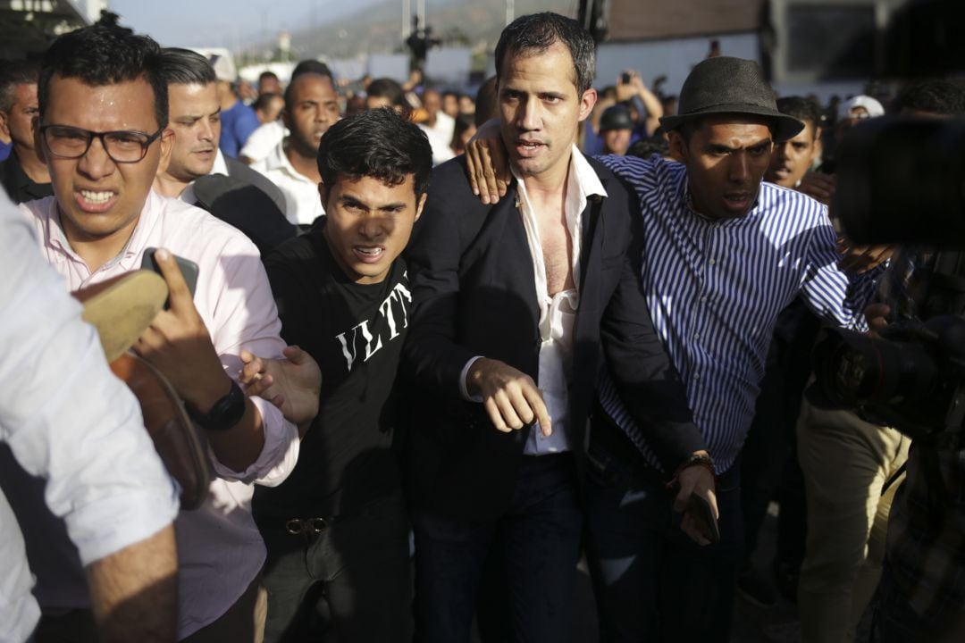 El líder de la oposición venezolana y autoproclamado presidente interino Juan Guaido es escoltado a su automóvil después de llegar al Aeropuerto Internacional Simón Bolívar en Maiquetía