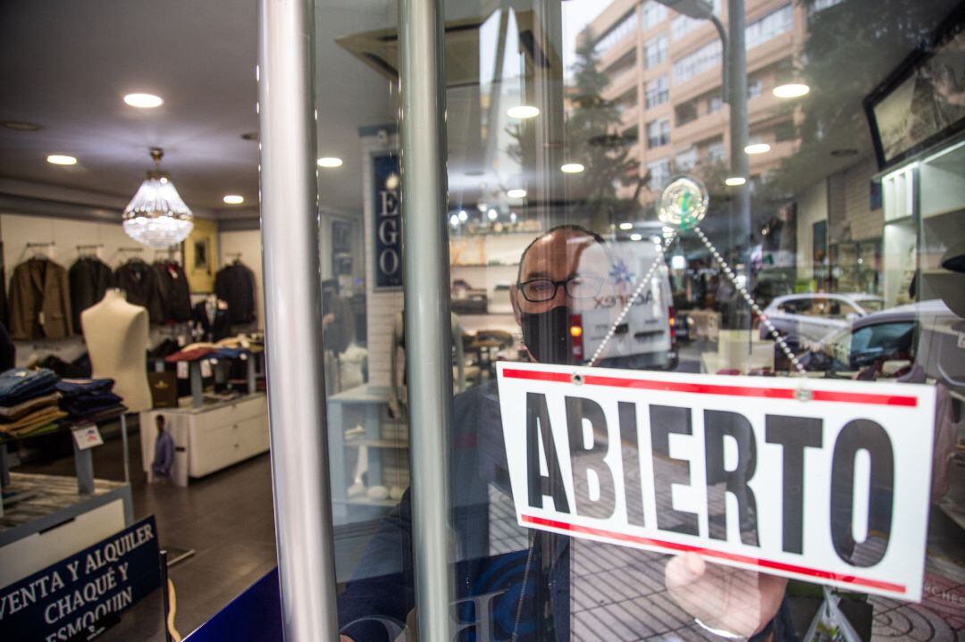 Un comercio muestra en su puerta un cartel donde se lee &quot;abierto&quot;, en Badajoz, Extremadura