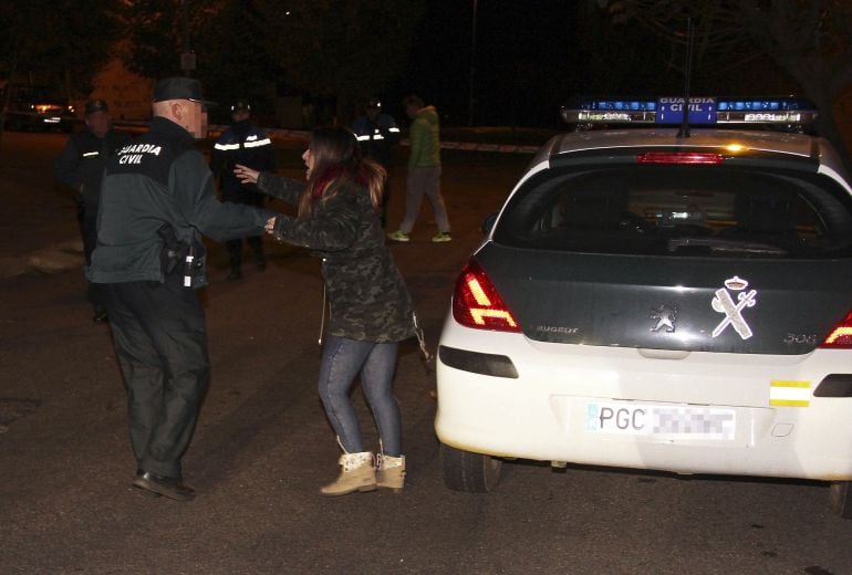 Un guardia civil habla con una mujer cerca de la vienda donde los cadáveres de un hombre y una mujer han sido hallados, en la localidad leonesa de La Virgen del Camino.