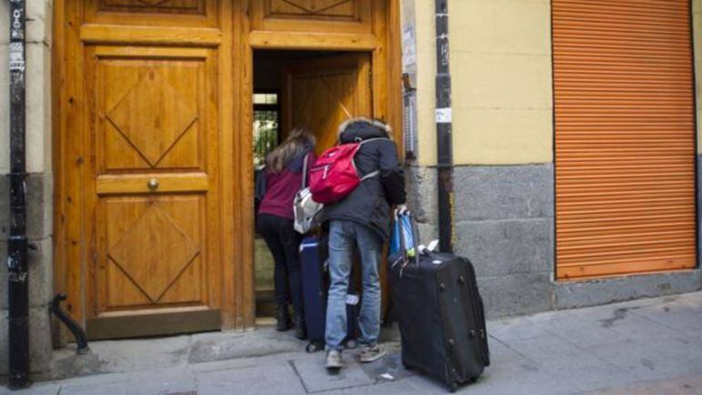 Unos turistas accediendo a un portal para alojarse en una vivienda turística