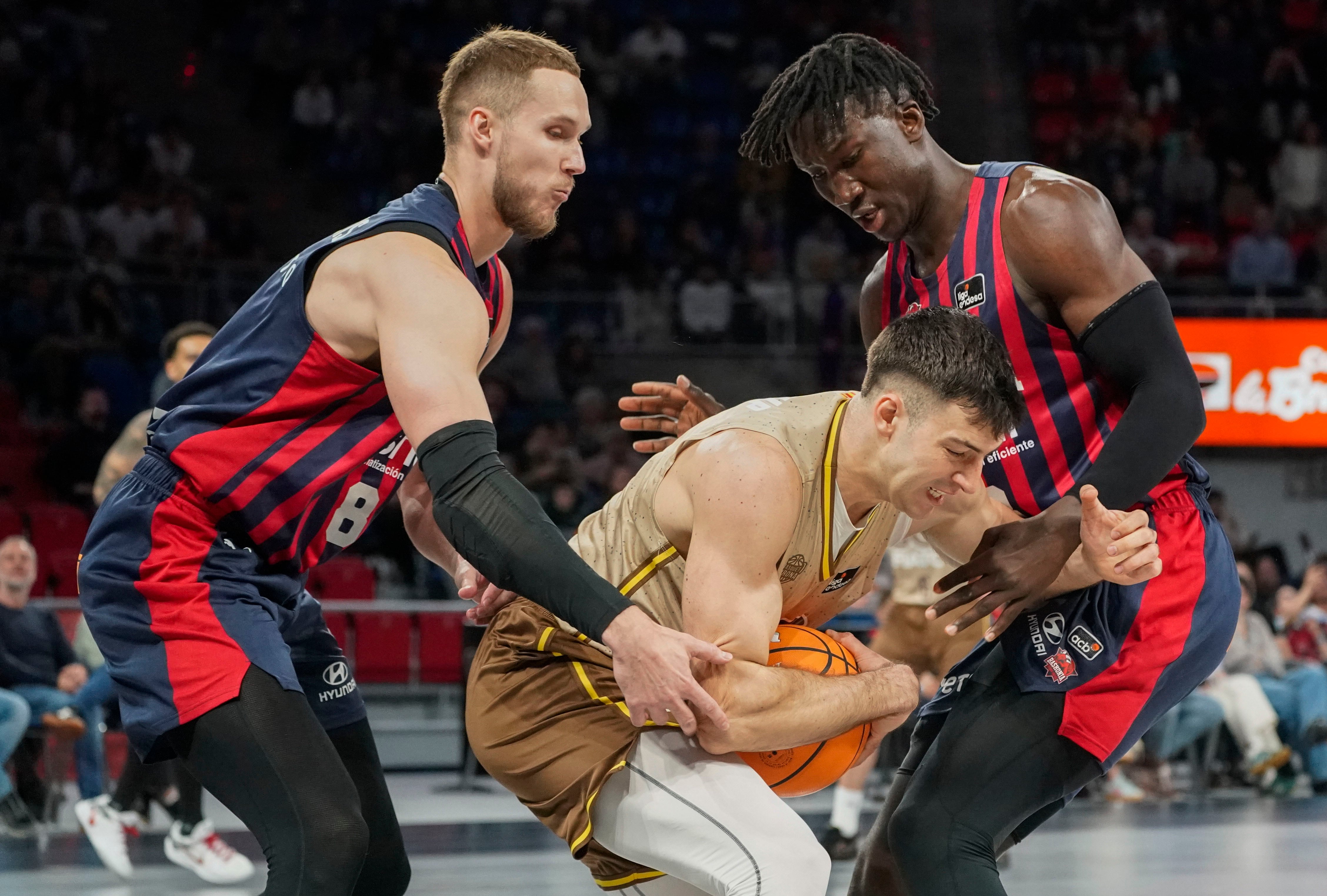 VITORIA, 06/04/2025.- Los jugadores del Baskonia Tadas Sedekerskis y Kalhipa Diop (dcha) pelean por el balón con el jugador del Bàsquet Girona Maxi Fjellerup, durante el partido correspondiente a la fase regular de la Liga Endesa disputado hoy domingo en el Buesa Arena de Vitoria. EFE/L. Rico
