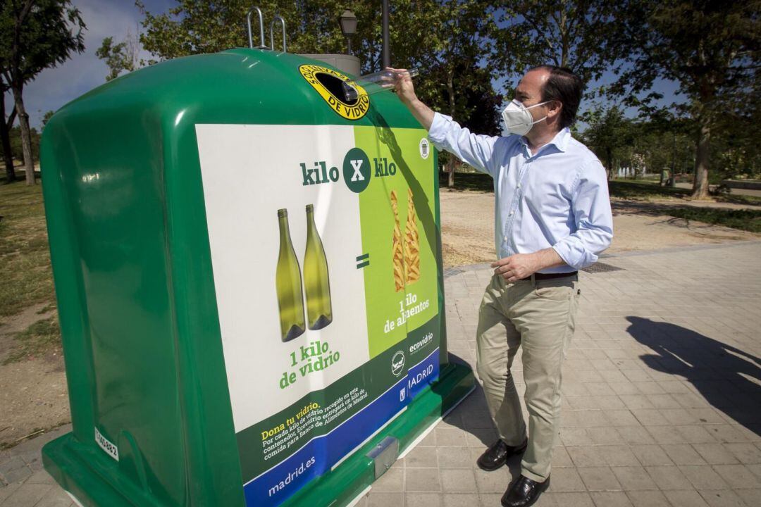 El delegado de Medio Ambiente y Movilidad, Borja Carabante, depositando un vidrio en uno de los contenedores situado en las inmediaciones de la boca de metro de Laguna