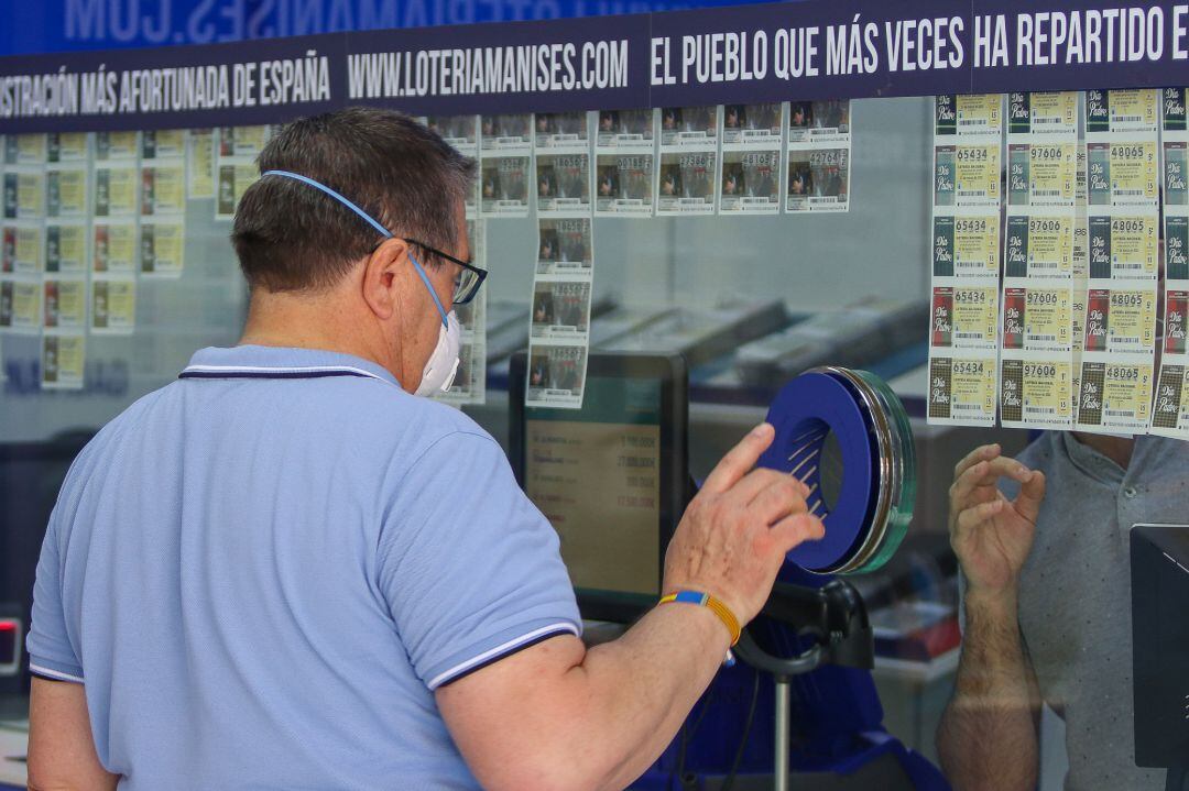 Un hombre compra lotería en una administración