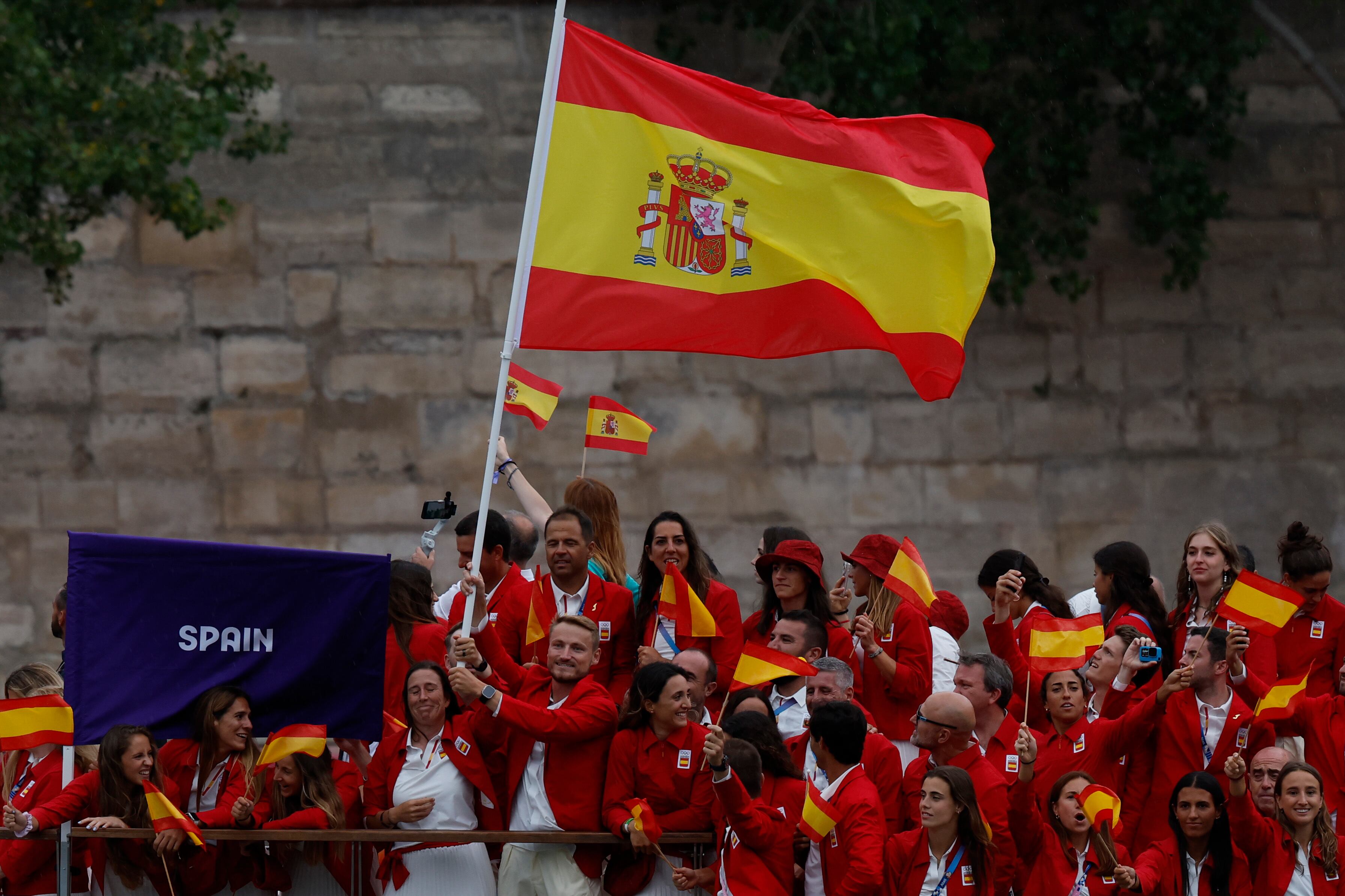 PARÍS (FRANCIA), 26/07/2024.- Los abanderados de España la regatista Támara Echegoyen (c-i) y el piragüista Marcus Cooper (c-d) junto al resto de la delegación durante el desfile por el río Sena, en el marco de la ceremonia de inauguración de los Juegos Olímpicos de París 2024, este viernes en la capital francesa. EFE/Julio Muñoz