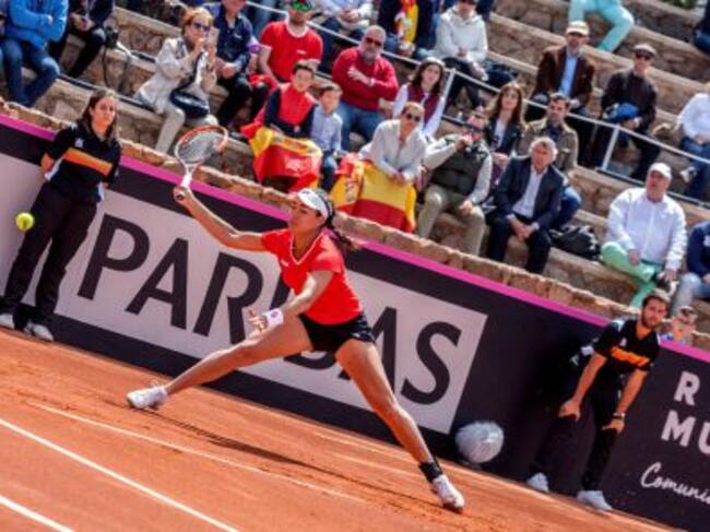 Montserrat González devuelve la bola a la española Garbiñe Muguruza en partido de la eliminatoria.