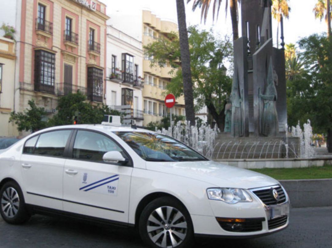 Un taxi, junto al monumento a las cofradías en la Alameda Cristina