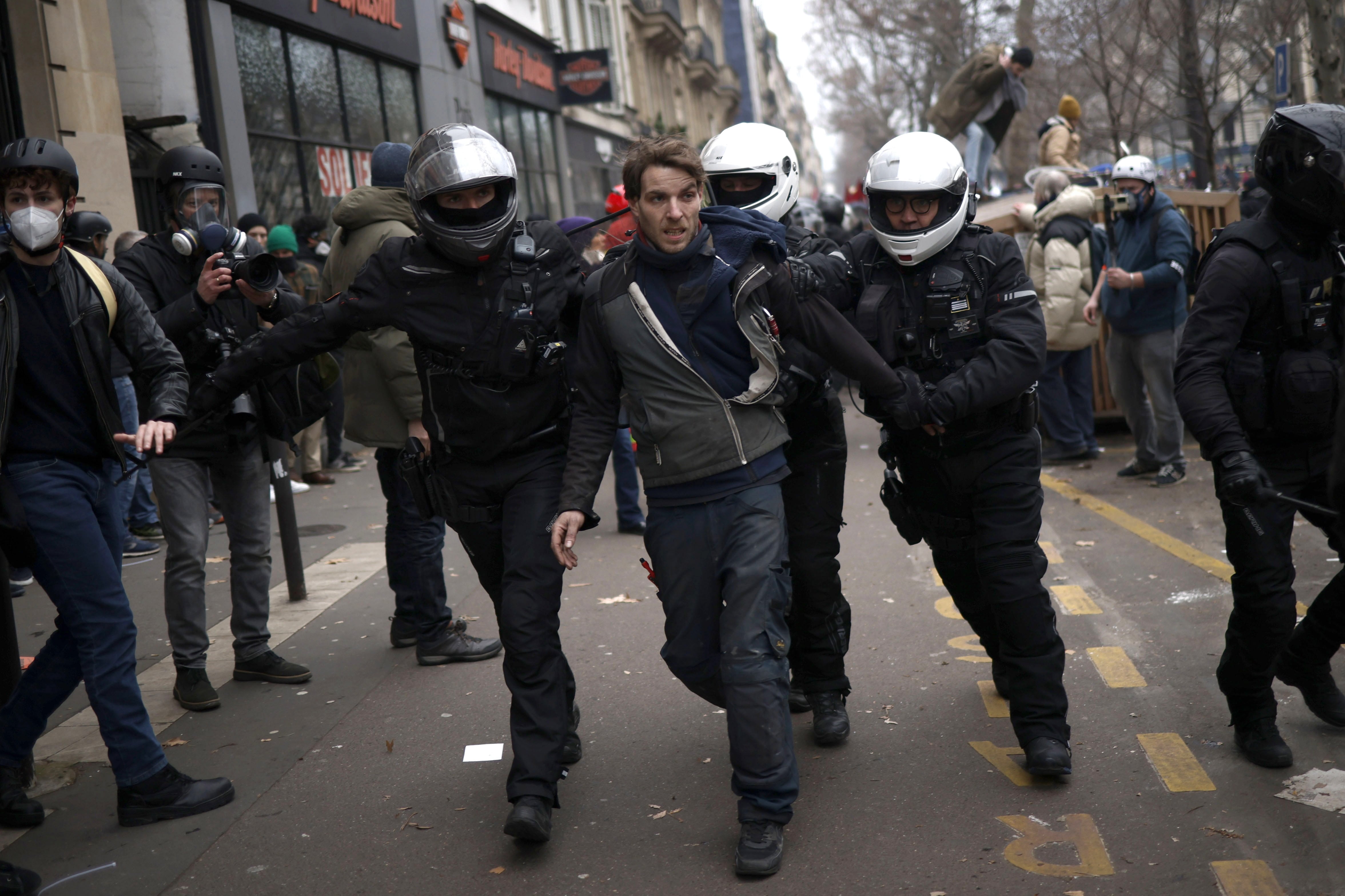 La policía francesa detiene a un protestante durante la manifestación nacional en París en contra de la reforma de las pensiones.