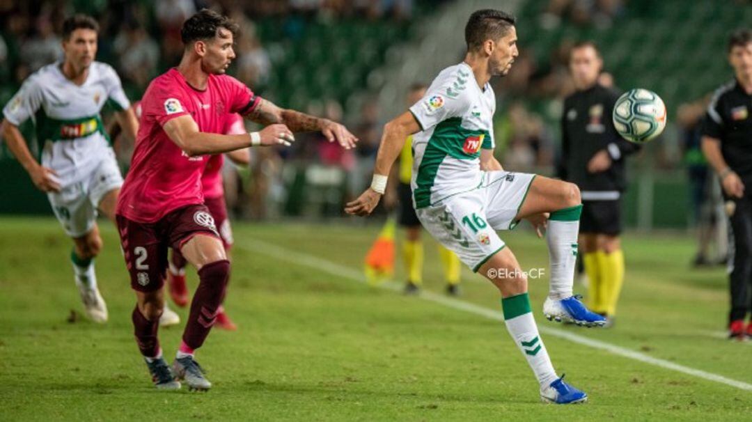 El jugador del Elche Fidel controla el balón ante Luis Pérez del Tenerife