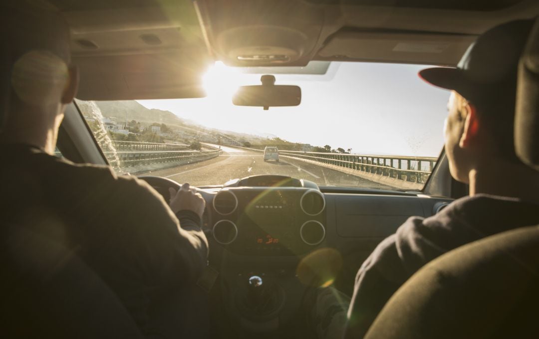 Dos personas viajan en el interior de un coche.