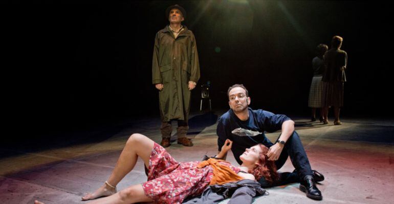 Escena de la obra de teatro 'Cuando deje de llover', con Felipe García Vélez de pie con gabardina y sombrero