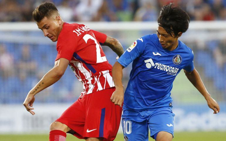  José María Giménez lucha el balón con el japonés Gaku Shibasaki, del Getafe.