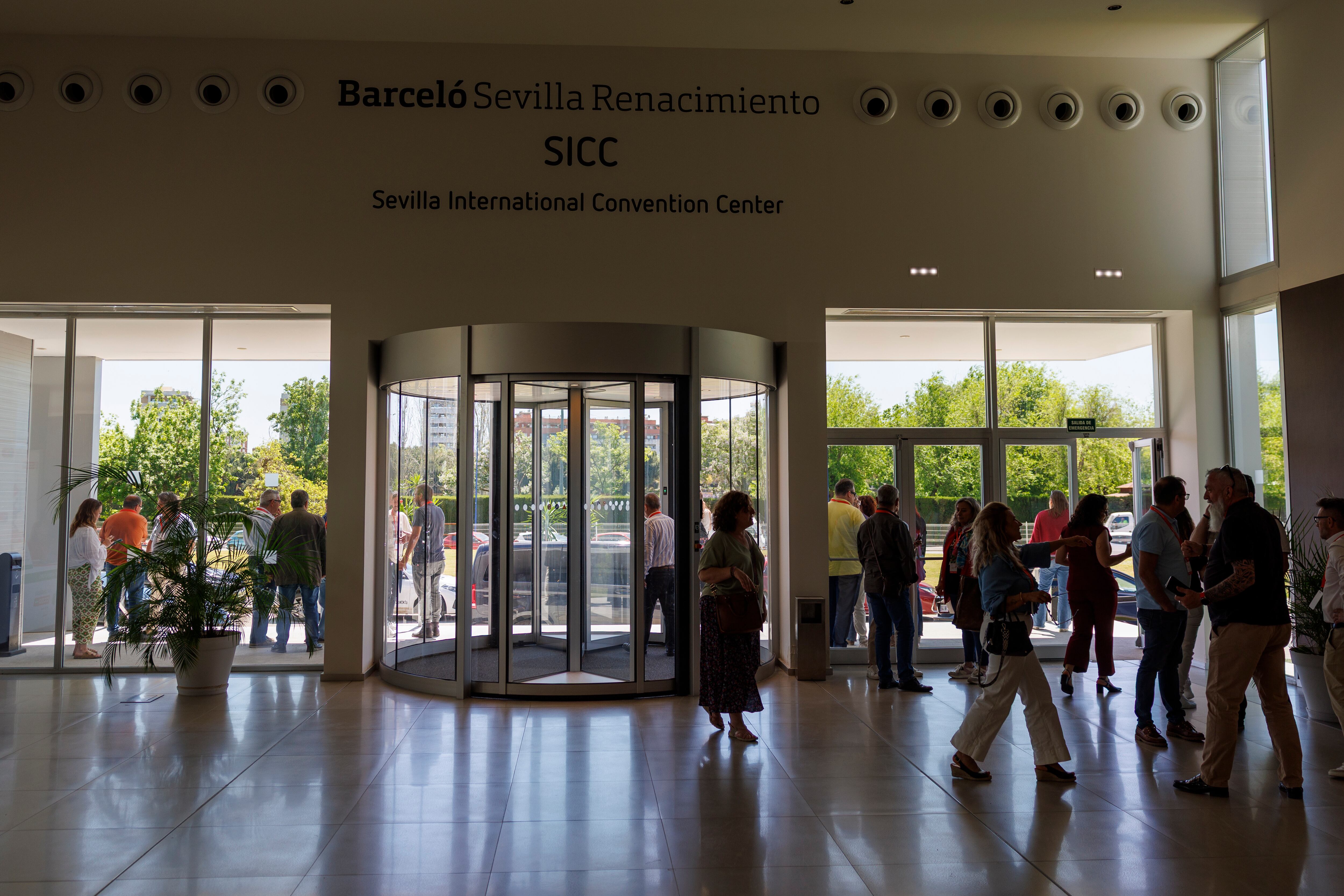 SEVILLA, 28/04/2025.- Participantes en el Congreso de CCOO de Andalucía en un hotel de Sevilla, en el que participaba el presidente andaluz, Juanma Moreno, buscan cobertura de móvil en la entrada del Centro de Convenciones anexo al Hotel Renacimiento en Sevilla tras el corte de suministro eléctrico que se ha producido hoy lunes. EFE/ Julio Muñoz