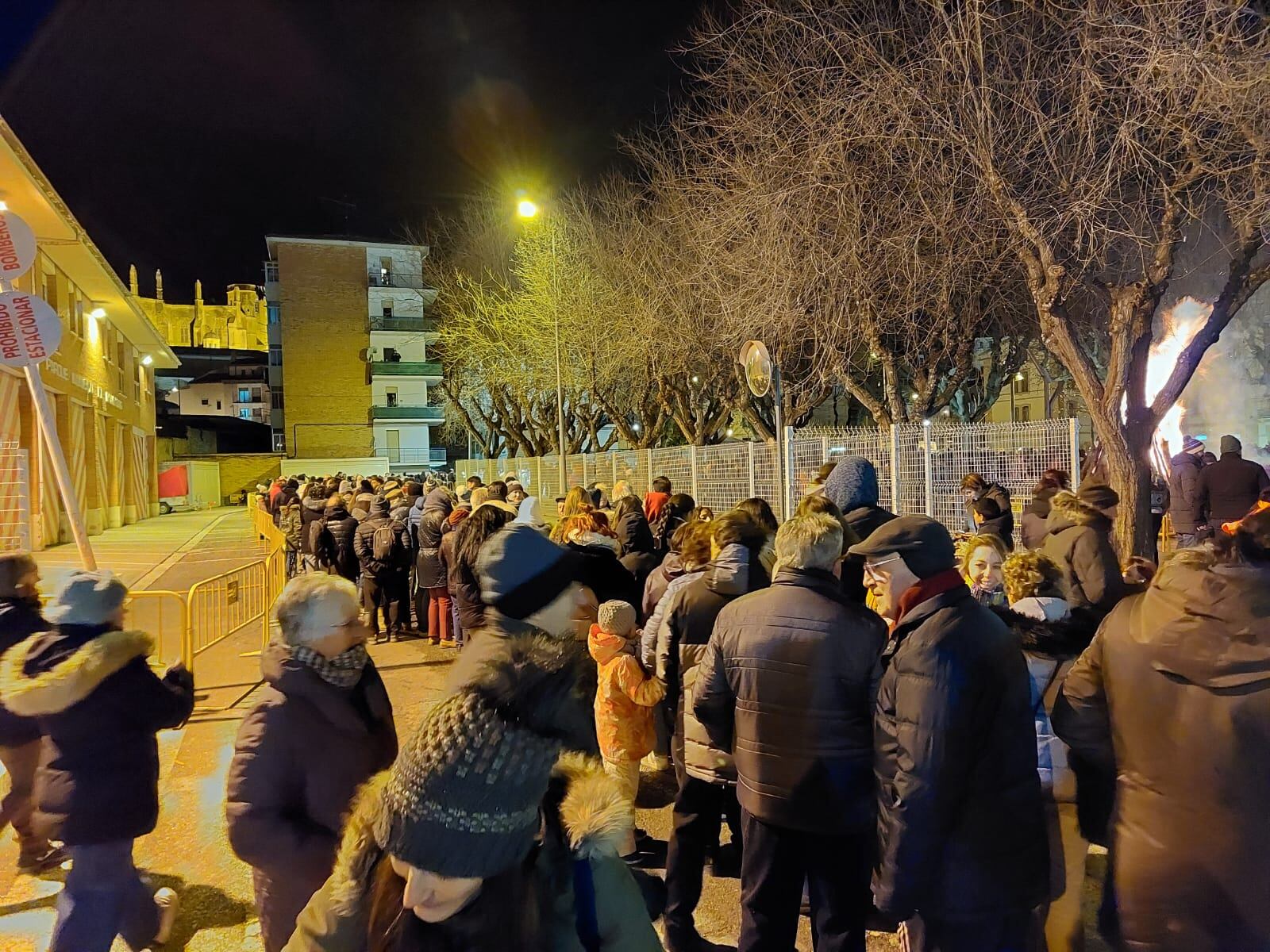 Largas  colas para recoger las patatas y la longaniza