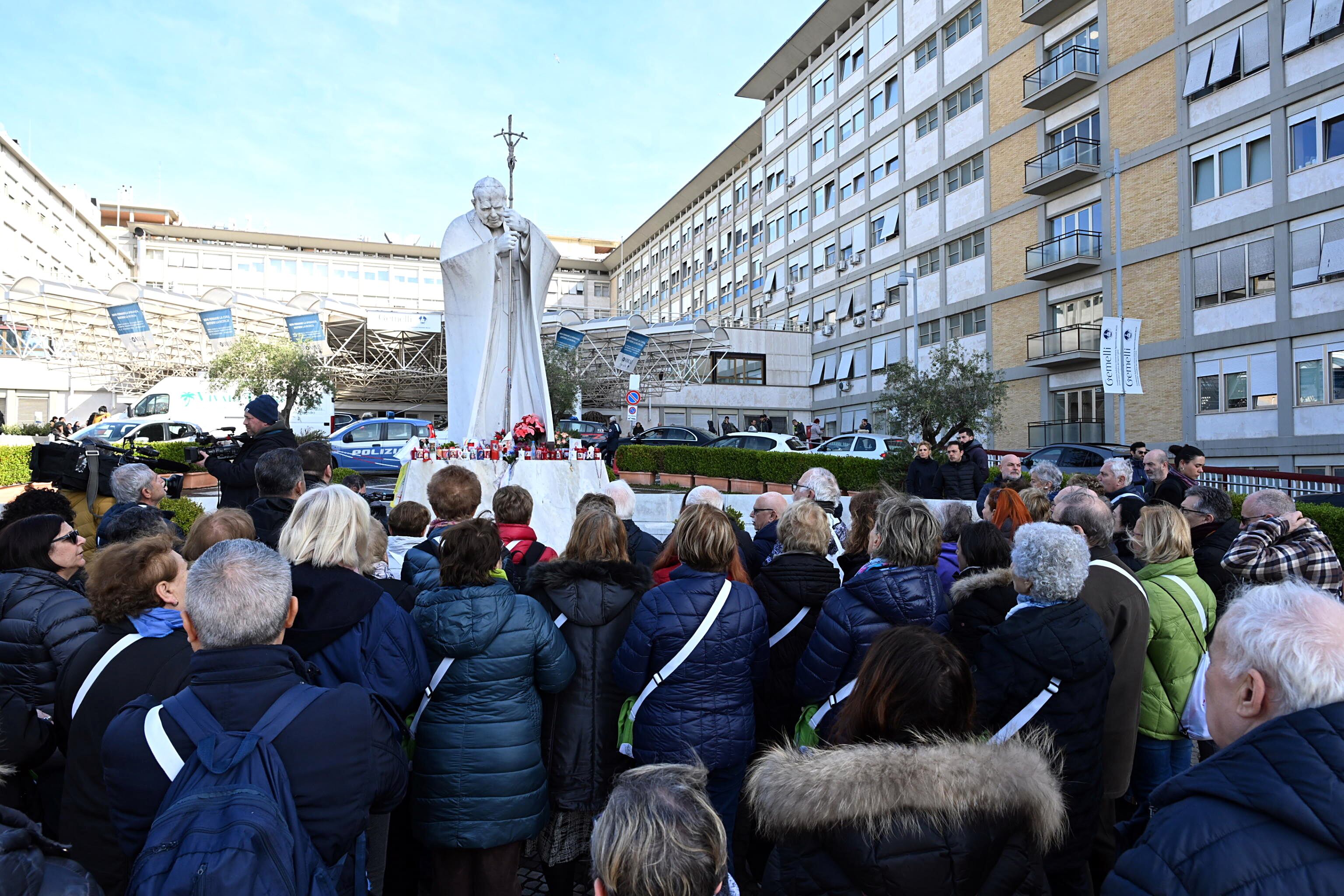 Varios seguidores rezan frente a la estatua del papa Juan Pablo en los exteriores del Hospital Gemelli de Roma por la salud del papa Francisco