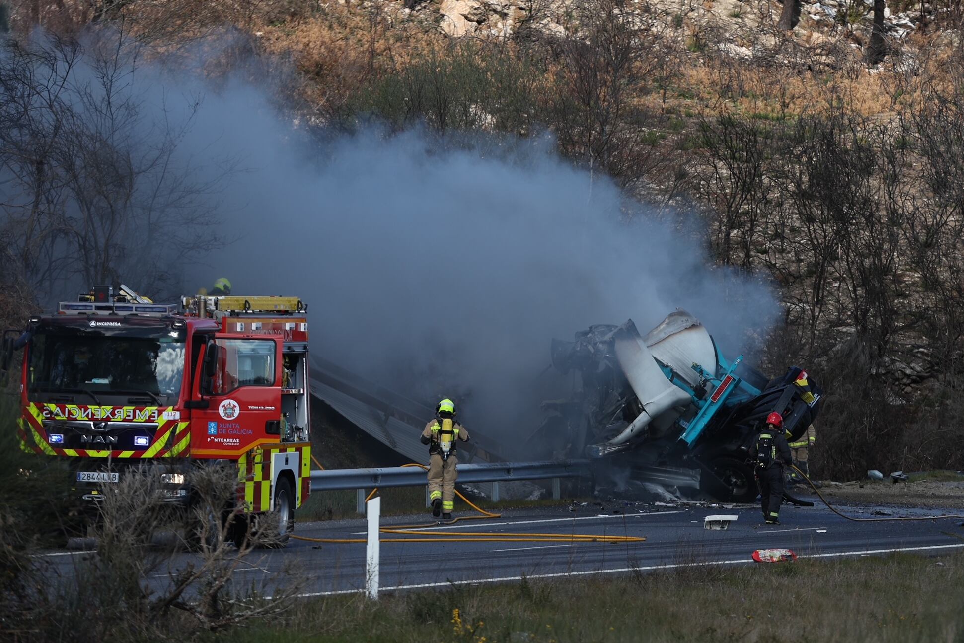 A CAÑIZA (PONTEVEDRA), 28/02/2023.- Bomberos y otros operativos de rescate asisten al camión cargado de poliestireno que ha volcado este martes a primera hora de la tarde en la A-52, a la altura de A Cañiza (Pontevedra), hecho que ha obligado a la Guardia Civil a cortar la circulación en ambos sentidos durante media hora al haberse inflamado la carga. EFE/ Sxenick
