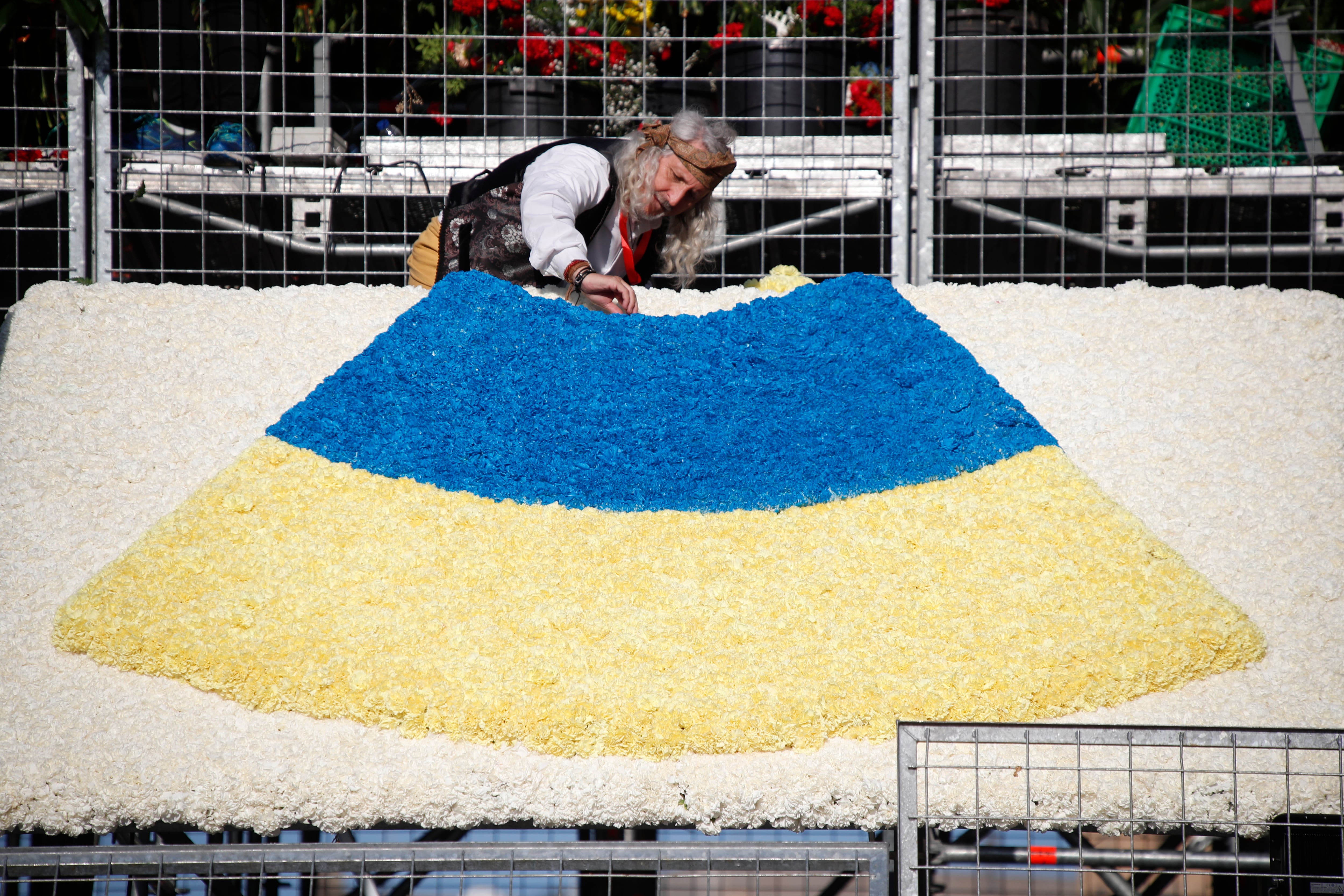 ZARAGOZA, 12/10/2022.- Un hombre coloca flores en la estructura de la Virgen del Pilar levantada en el centro de la plaza de Zaragoza que lleva su nombre en una ofrenda llena de ilusión que se espera de récord tras dos años de pandemia, con más grupos inscritos que en 2019 y la previsión de alcanzar alrededor de siete millones de flores. EFE/ Javier Cebollada
