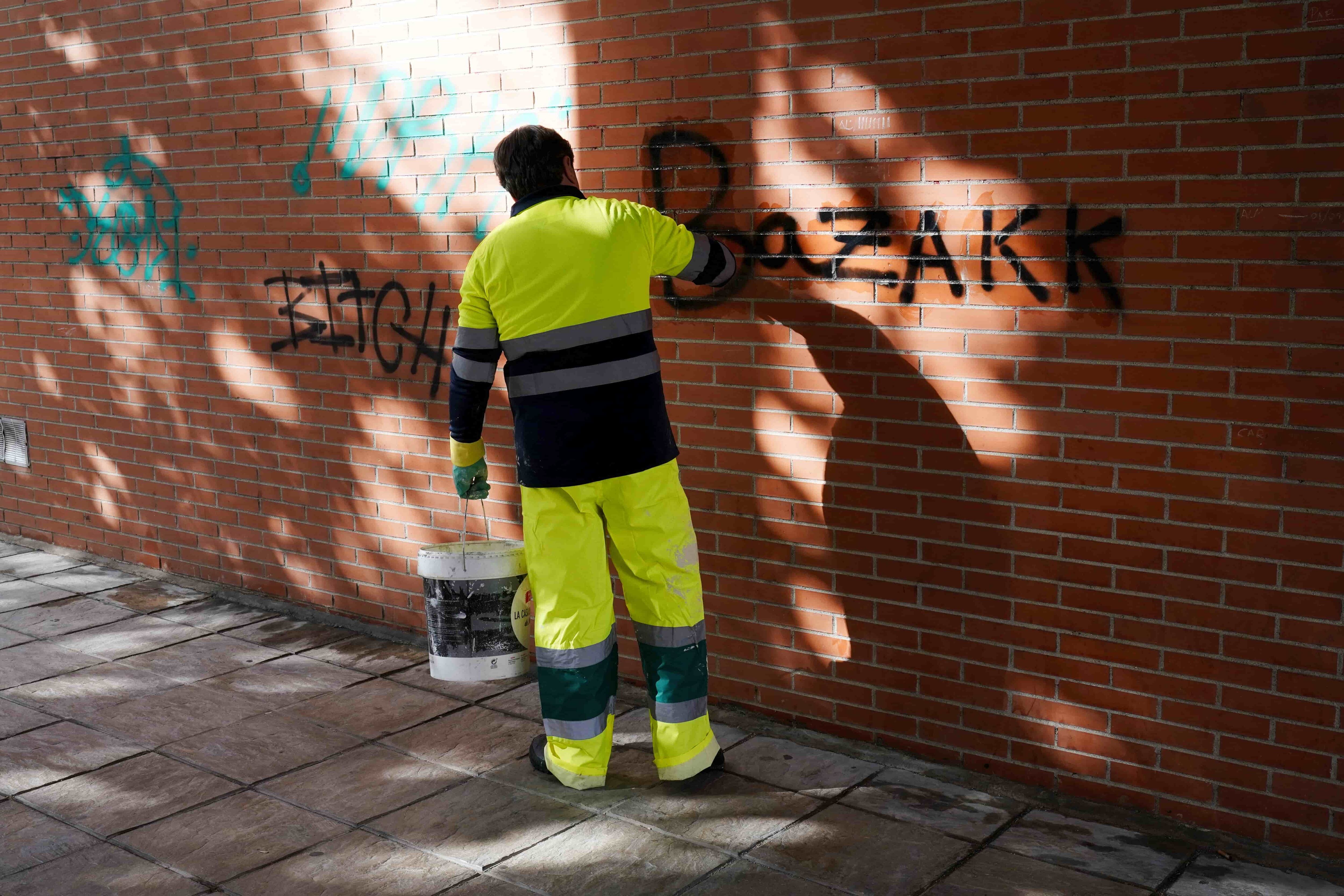 Un operario inicia la limpieza de pintadas en una fachada de San Sebastián de los Reyes