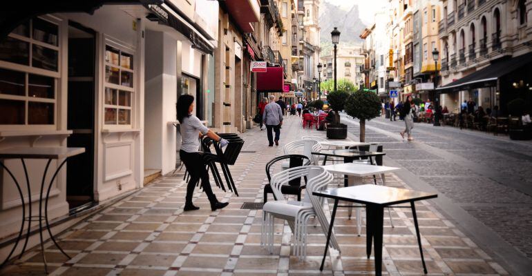 Una persona prepara la terraza de un bar.