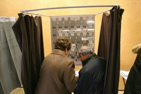 Dos personas preparan sus papeletas en la mañana de este 25 de noviembre, en un colegio electoral de Tarragona.