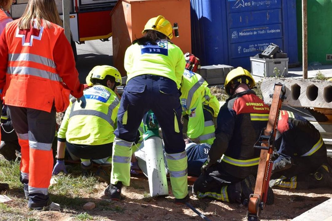 Miembros de bomberos, emergencias y Cruz Roja atienden a un herido durante el simulacro de inundación.