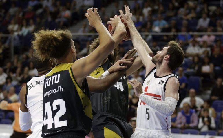 GRA505. MADRID, 24/05/2015.- Los jugadores del Real Madrid Rudy Fernández (d) y Marcus Slaughter (i) y el alal pívot de La Bruixa D&#039;Or Manresa Isaac Fotu, durante un partido en el Palacio de los Deportes.