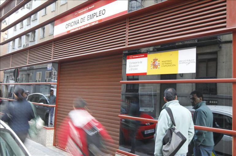 Varios ciudadanos pasan ante una Oficina de Empleo