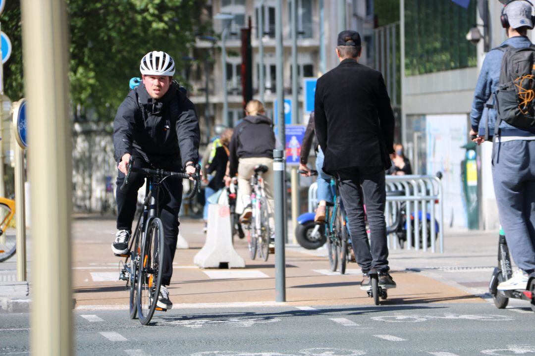 Pla mitjà d&#039;un ciclista i un noi en patinent circulant pel centre de Brussel·les durant la primera setmana de desconfinament, el 5 de maig del 2020. (Horitzontal)