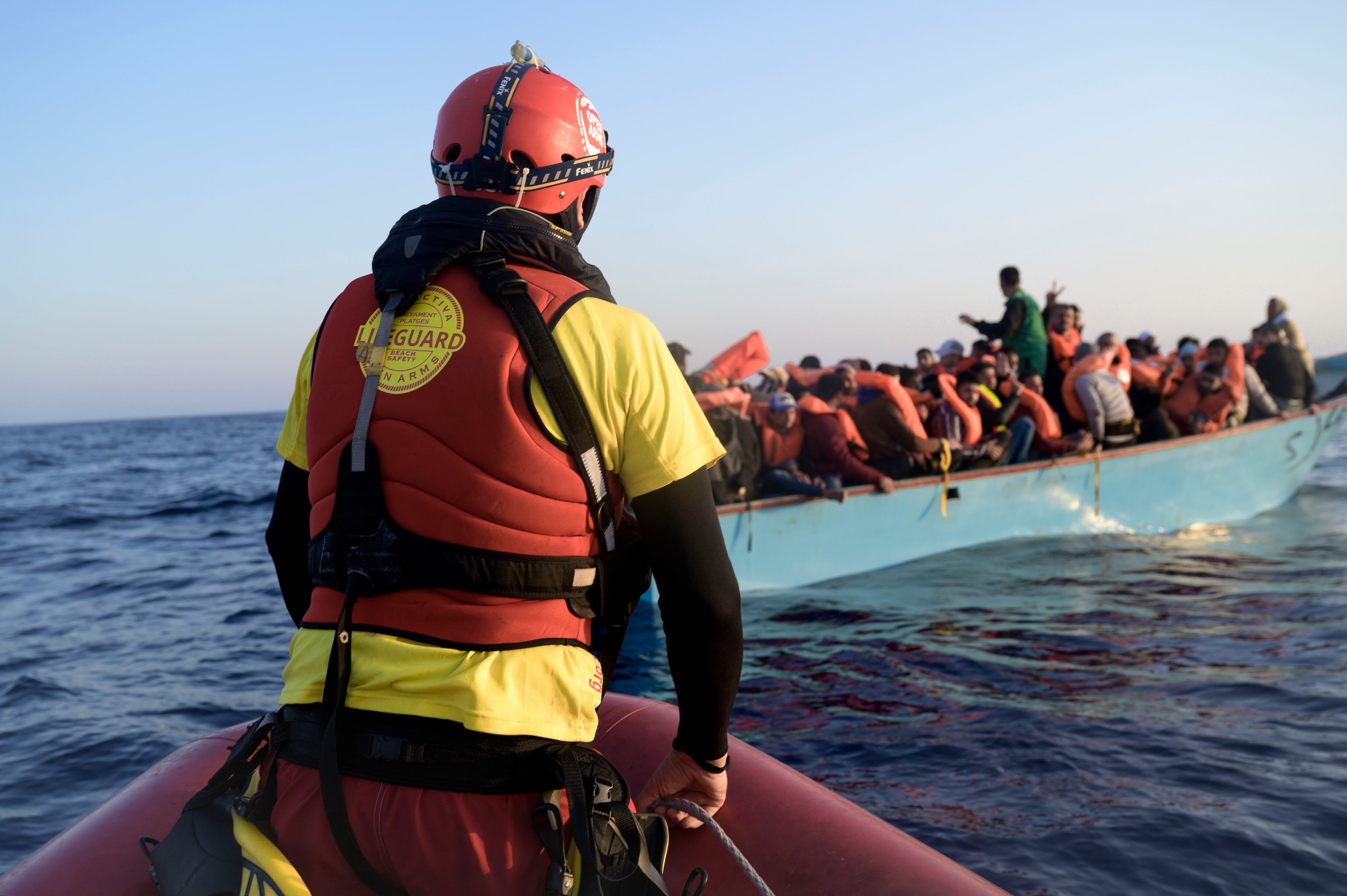 Un equipo de la ONG Open Arms se aproxima a una embarcación en la que cerca de 70 migrantes llegaron a las costas italianas en mayo