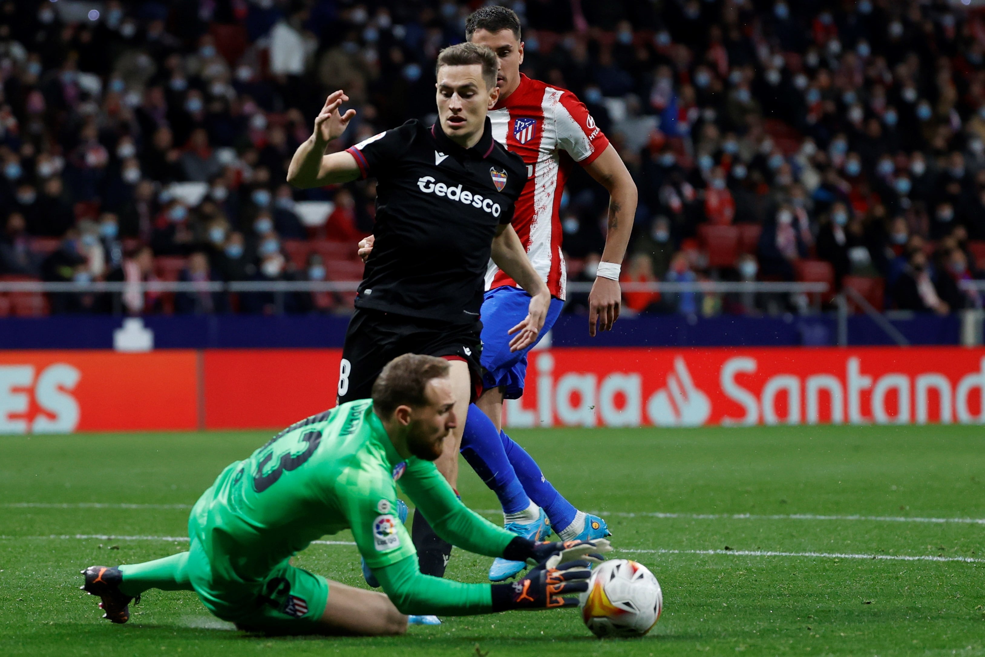 El guardameta esloveno del Atlético de Madrid, Jan Oblak, detiene el balón ante el delantero del Levante UD, Jorge de Frutos en el estadio Wanda Metropolitano EFE / Juanjo Martín.