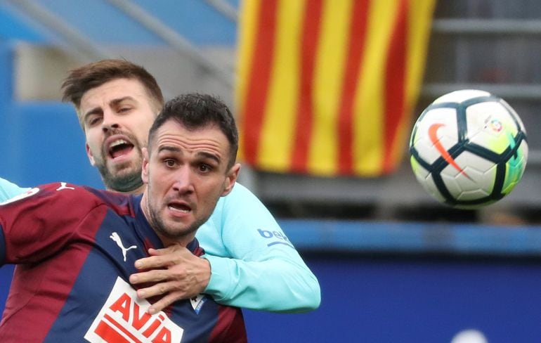 - El delantero del Eibar Kike García (primer térmono) y el defensa del FC Barcelona, Gerard Piqué (i) durante el partido de la vigésimo cuarta jornada de Liga que disputan en el estadio de Ipurúa de Eibar (Guipúzcoa). 