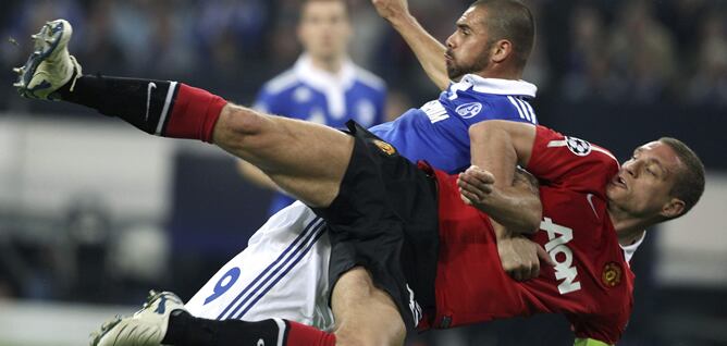 Edu (i) del FC Schalke 04 lucha por el balón con Nemanja Vidic (d) del Manchester United durante su partido de ida de la semifinal de la Liga de Campeones de fútbol que se juega en el Veltins-Arena de Gelsenkirchen, Alemania, hoy martes 26 de abril de 201