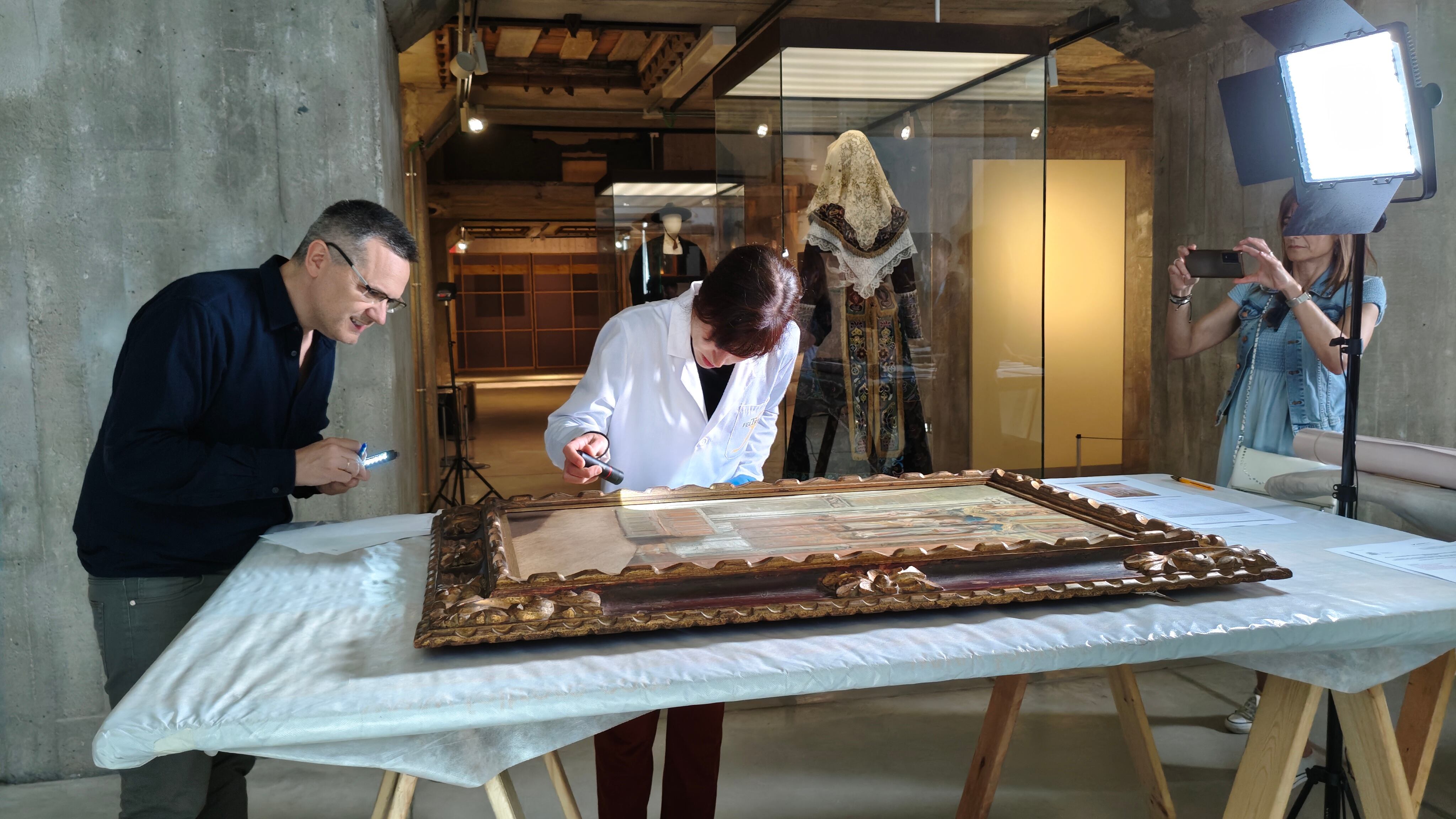 El conservador y la restauradora verifican el estado de la obra