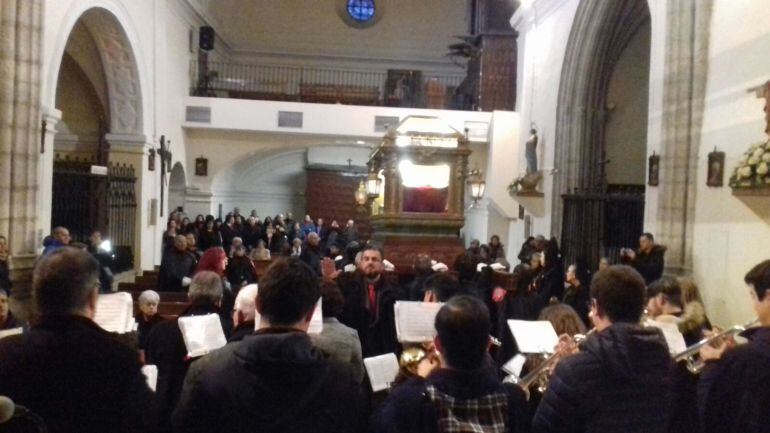 La Banda Municipal de Música interpreta varias piezas ante la imagen del Cristo Yacente portada en hombros en el interior de la iglesia de San Miguel 